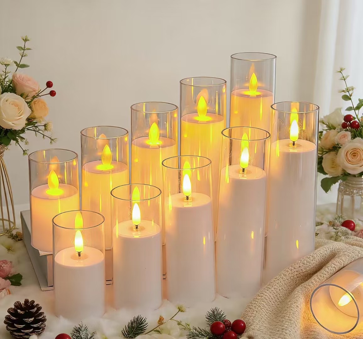 White LED pillar candles glowing inside clear glass cylinders